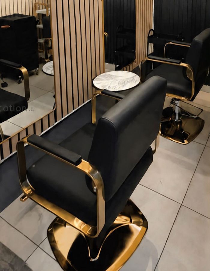 The Ganya Hair studio: black and gold styling chairs against timber slat panels